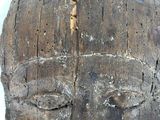 a close up of a wooden head on a white surface