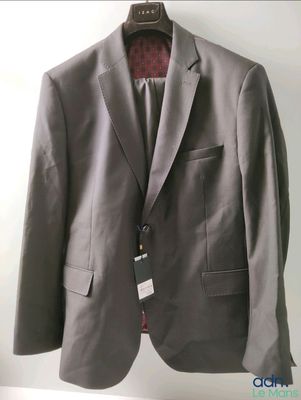 grey suit jacket hanging on a hanger on a white wall