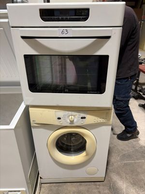 un homme debout à côté d'une pile d'appareils électroménagers