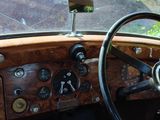 steering wheel and dashboard of an old car with wood paneling
