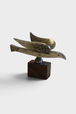 sculpture of a bird on a wooden base on a white background