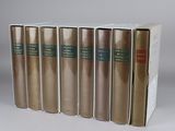 six books are lined up in a row on a white surface