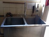 a stainless steel sink in the corner of a kitchen