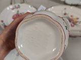 a person holding a cup and saucer in their hand
