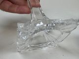a hand that is holding a glass object on a table
