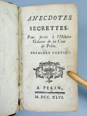 un livre ouvert d'où sort un crayon, posé sur une surface bleue
