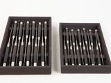 two black boxes filled with different types of needles on a white surface