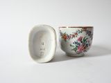 a small cup and saucer sitting next to each other