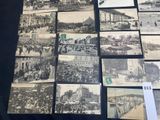 several old black and white photographs of people and vehicles on display