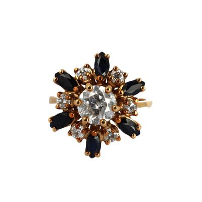 gros plan d'une bague en or avec des pierres noires et blanches