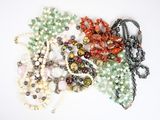 beaucoup de perles et de colliers sur un fond blanc