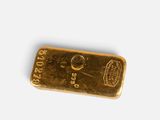 a close up of a gold bar on a white surface