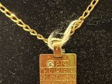 a close up of a gold plated necklace on a black surface