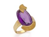 un gros plan d'une bague en pierre violette sur fond blanc