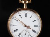 une montre de poche en or avec des chiffres romains
