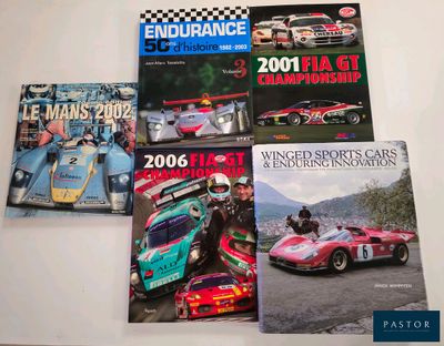 three books on a table with a racing car in front of them