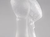 une figurine en verre transparent surmontée d'un oiseau