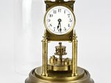 a gold clock under a glass dome on a table