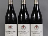 trois bouteilles de vin rouge sont alignées sur une table