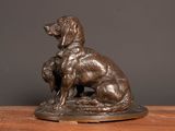 bronze statue of a dog and a cat on a wooden table