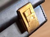 a close up of a black purse with a gold buckle