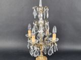 an antique brass and crystal chandelier with three lights