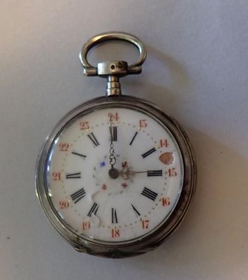 une montre de poche en argent avec des chiffres romains sur le cadran