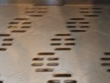 a close up of a metal grill with holes in it