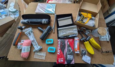 une table sur laquelle sont posés de nombreux objets, notamment des ciseaux, de la colle, de la colle, un pistolet à colle, un pistolet à colle, un pistolet à colle, un pistolet à colle, de la colle