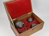 a wooden box with two metal skulls inside of it