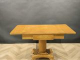 an antique oak dining table with pedestal base