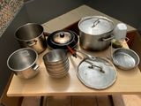many pots and pans sitting on a wooden table