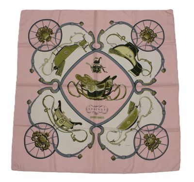 a close up of a pink scarf with a bird and carriage design