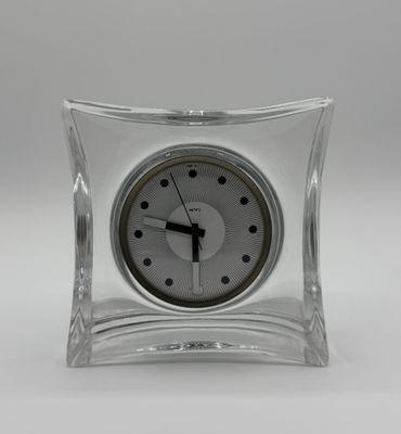 une horloge en verre posée sur une table