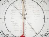 a large clock with a red hand on it ' s face