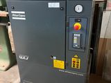 an air compressor sitting on top of a pallet in a warehouse