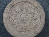 an old silver plate with a design of flowers and leaves