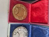 three medals in a case with a ribbon around them