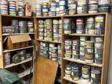 many cans of paint on the shelves in the room