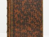 a brown and black book sitting on top of a white surface