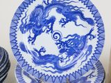 several blue and white plates with dragon designs are stacked on top of each other