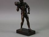 bronze statue of a man holding a football ball on a marble base
