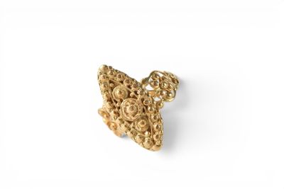 a close up of a piece of gold jewelry on a white surface
