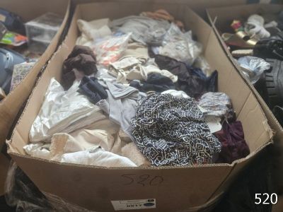 a cardboard box full of clothes on the floor