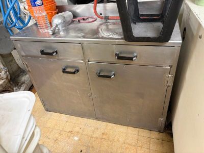 a machine that is sitting in a kitchen next to a trash can