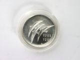 a close up of a coin in a plastic container on a white surface