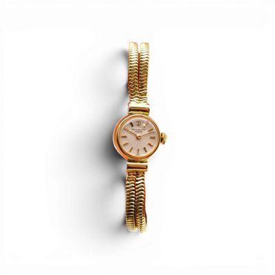 une montre-bracelet pour femme avec un bracelet en or sur fond blanc