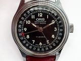 a wrist watch with a black dial on a red leather strap