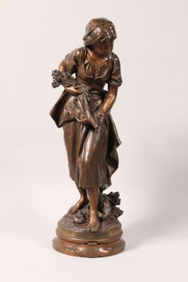 une statue antique en bronze représentant une femme tenant un bébé dans ses bras