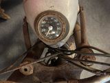 a close up of a motorcycle with a clock on the handlebars